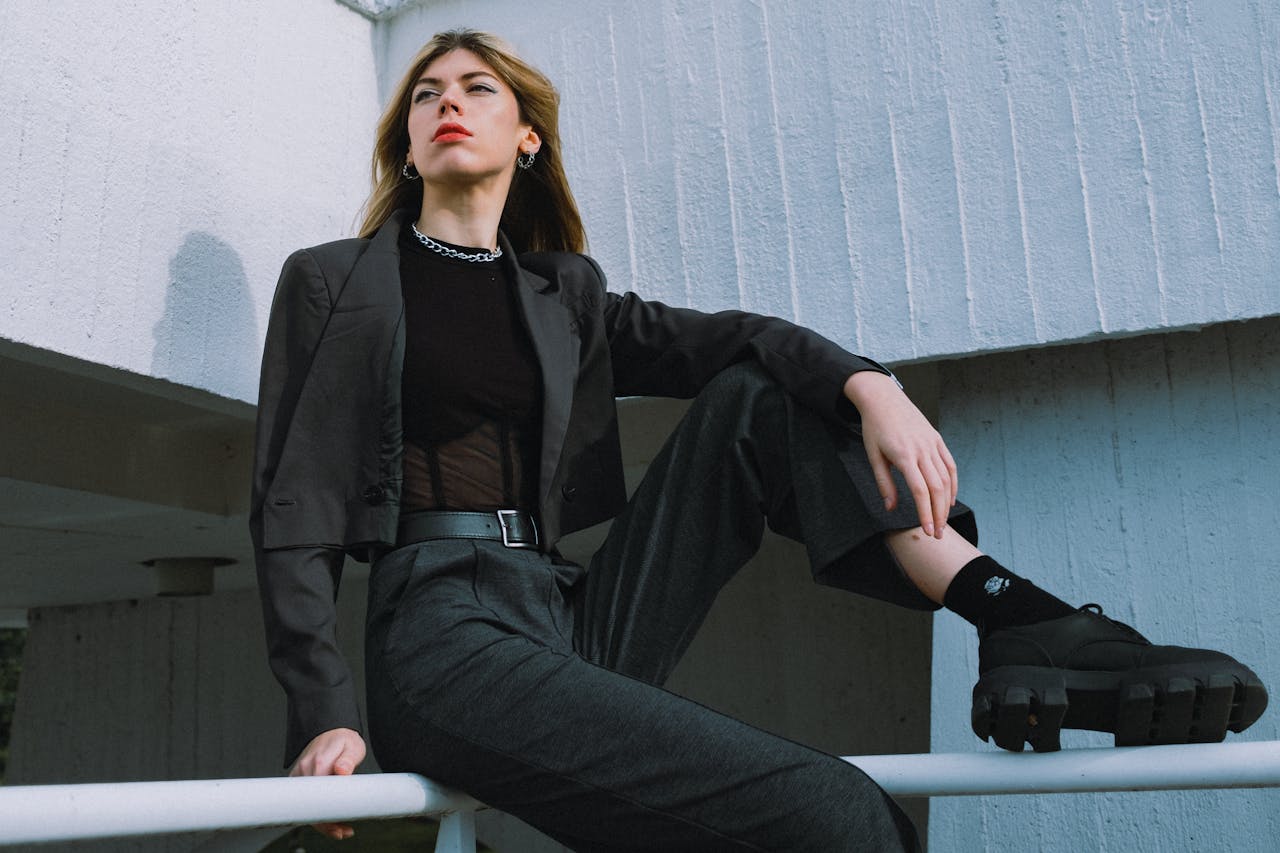 hero-img-01 Fashionable woman in a suit sitting outdoors showcasing a modern style in Berlin.